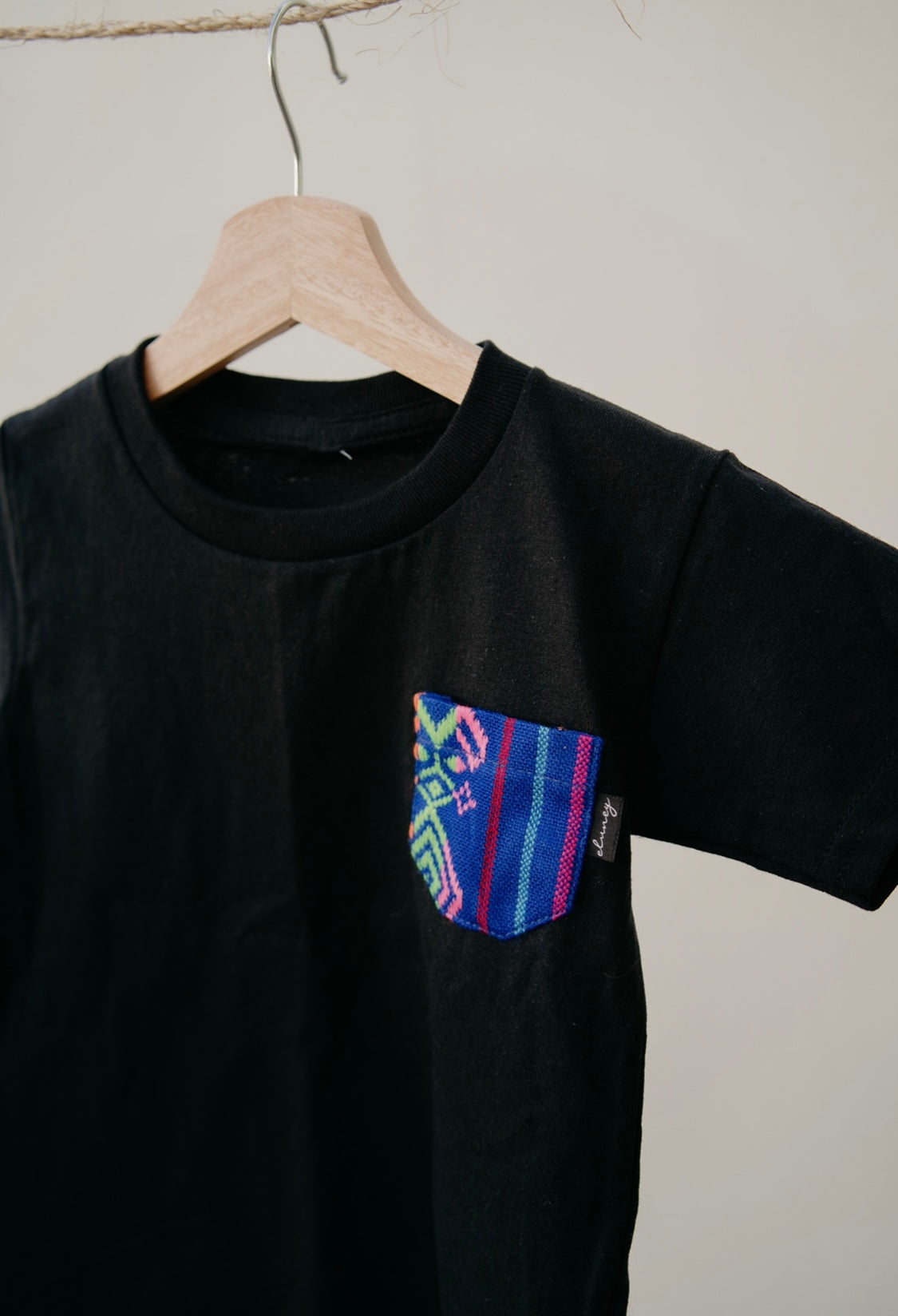 Playera Infantil negro con bolsillo azul