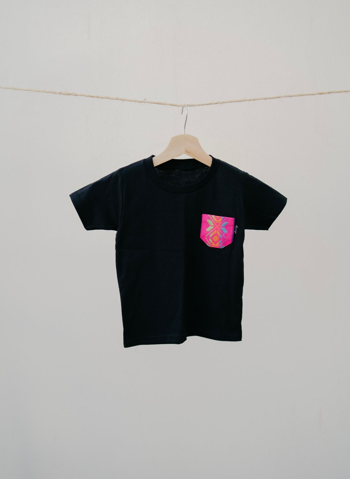 Playera Infantil negro con bolsillo rosa